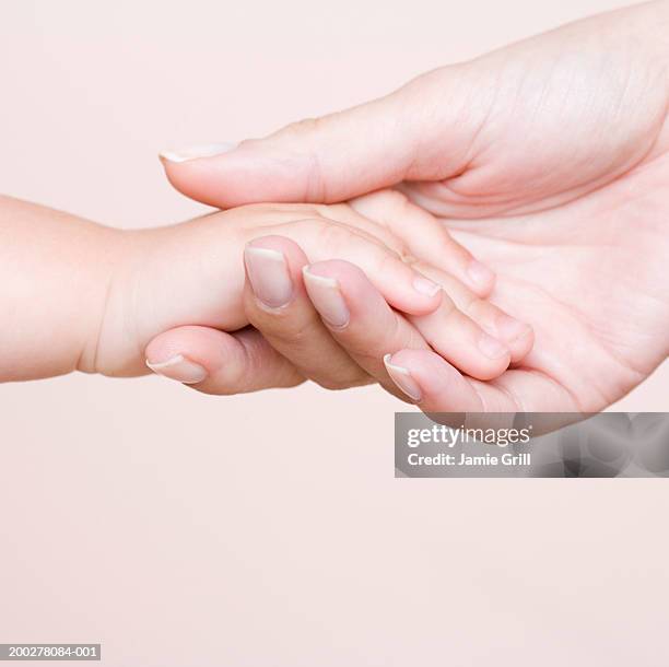 mother and baby holding hands, close-up - baby hands ストックフォトと画像