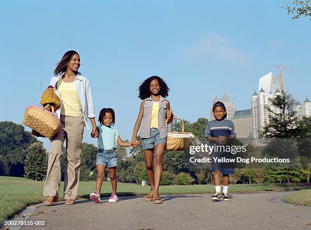 mother and children (5-13) entering park with picnic gear - piedmont park stockfoto's en -beelden