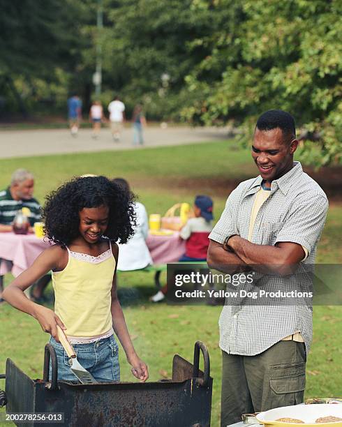 girl (11-13) grilling food at picnic, father watching - atlanta georgia park stock pictures, royalty-free photos & images