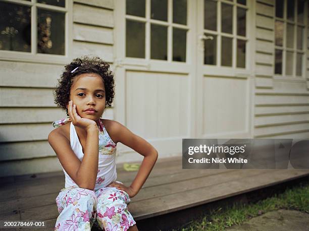 girl (6-8) sitting on porch step, portrait - african american girl child photos et images de collection