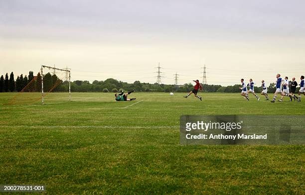 mixed football match, opposing team chasing player towards goal - partido rondas deportivas fotografías e imágenes de stock