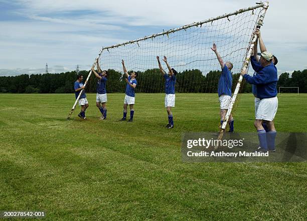 football team erecting goal on pitch - amature stock pictures, royalty-free photos & images