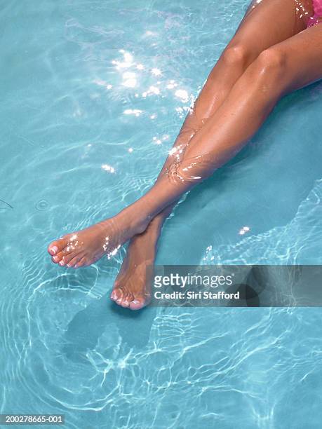 young woman in pool (low section) - pés cruzados - fotografias e filmes do acervo