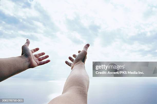 man stretching arms up to sky, close-up - out of reach stock pictures, royalty-free photos & images