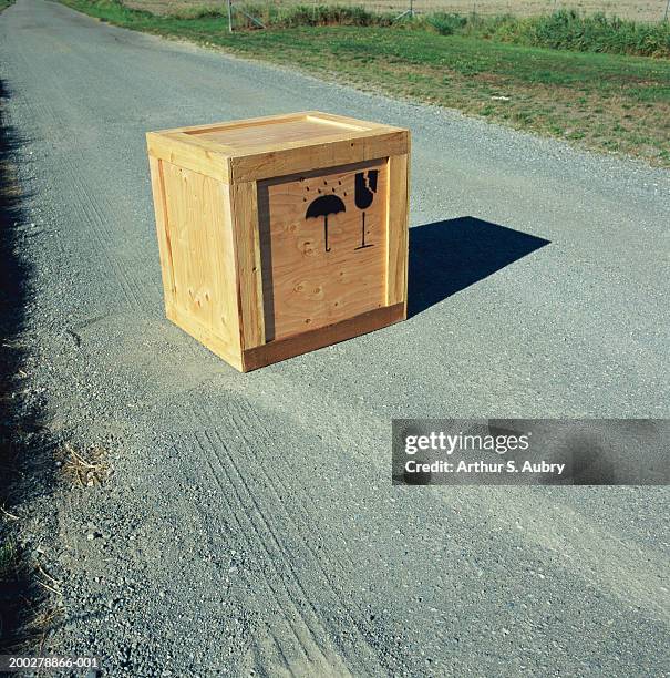 wooden crate with 'fragile' and 'do not get wet' symbols on road - boxwood photos et images de collection