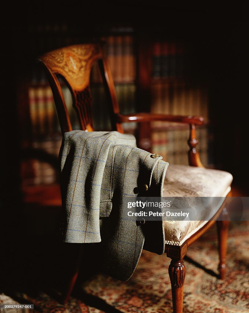 Jacket hanging over arm of wooden chair