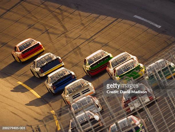 stock car race, safety fence in foreground, elevated view - nascar stock pictures, royalty-free photos & images