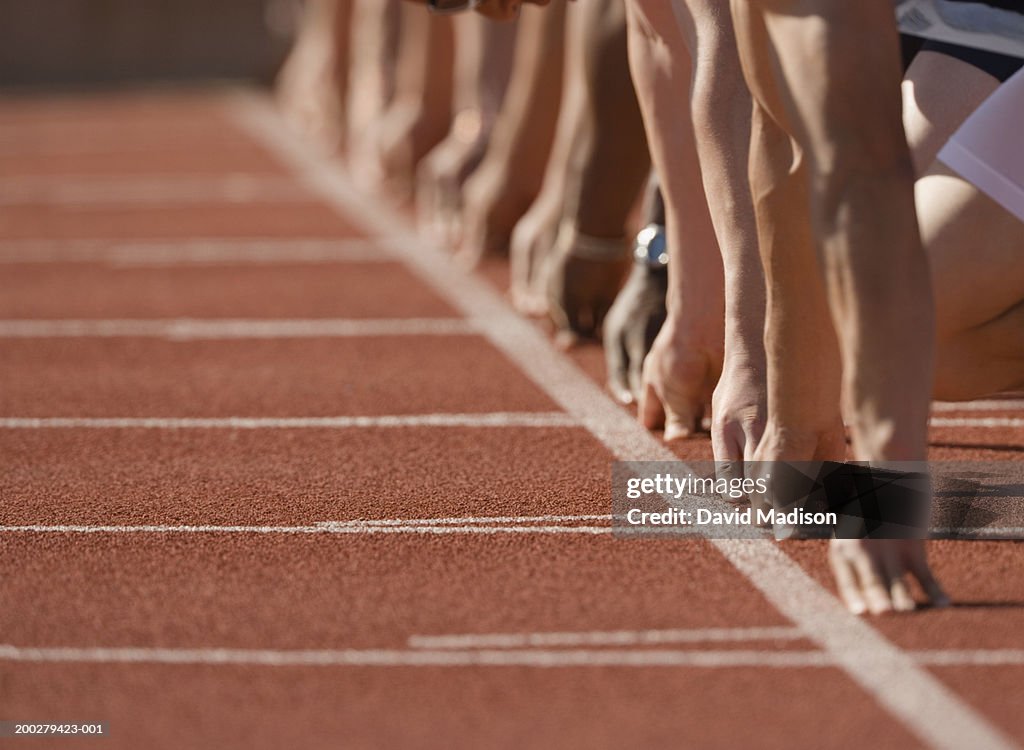 Runners at start of race, hands behind start line, low section