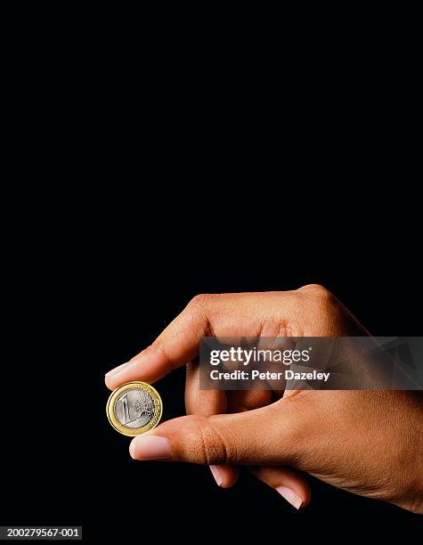 woman holding one euro coin - one euro coin stock pictures, royalty-free photos & images