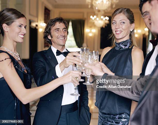adults wearing formal attire, toasting champagne glasses - formele kleding stockfoto's en -beelden