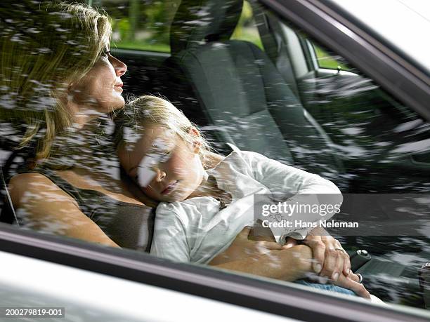 girl (4-6) asleep in mothers lap in car (blurred motion) - sleeping in car foto e immagini stock