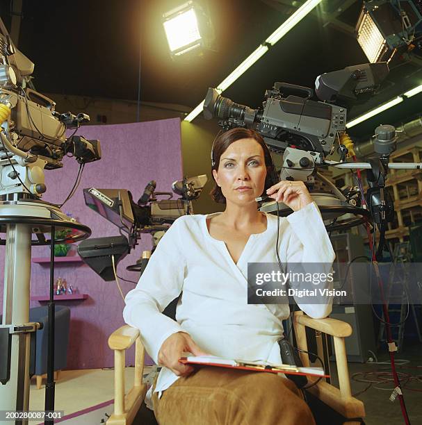 woman sitting in 'director's chair', cameras in background, portrait - cadeira de diretor - fotografias e filmes do acervo