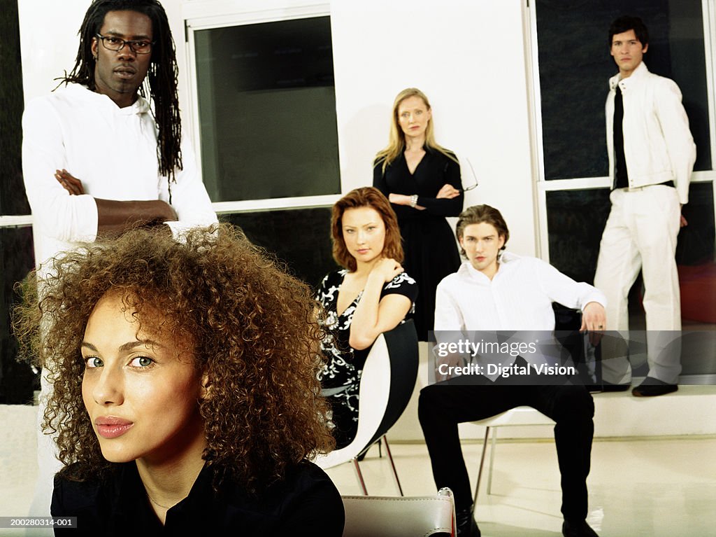 Group of people sitting and standing indoors, portrait