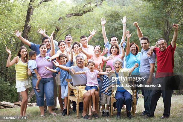 portrait of a three generation family waving - riunione di famiglia foto e immagini stock