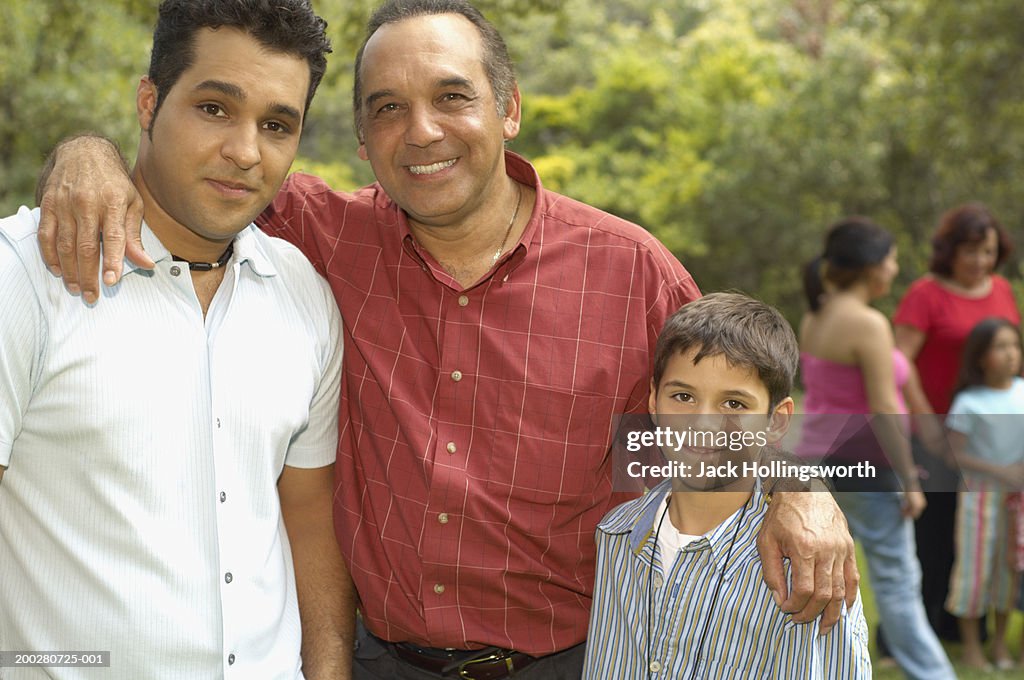 Portrait of a mature man with his arm around his son and his grandson