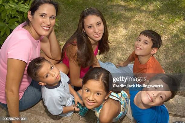 high angle view of a young woman sitting in a garden with five children - family with five children stock pictures, royalty-free photos & images
