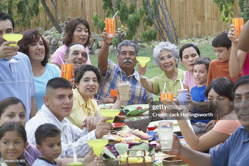 Portrait of a three generation family raising a toast at a picnic table