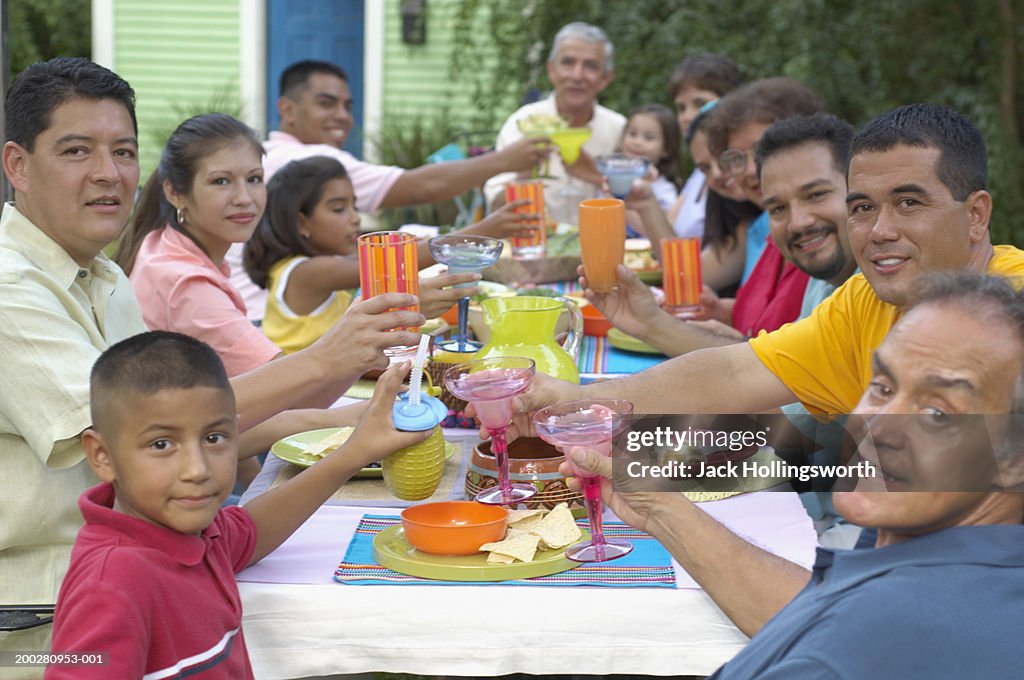 Portrait of a group of people raising a toast at a picnic table
