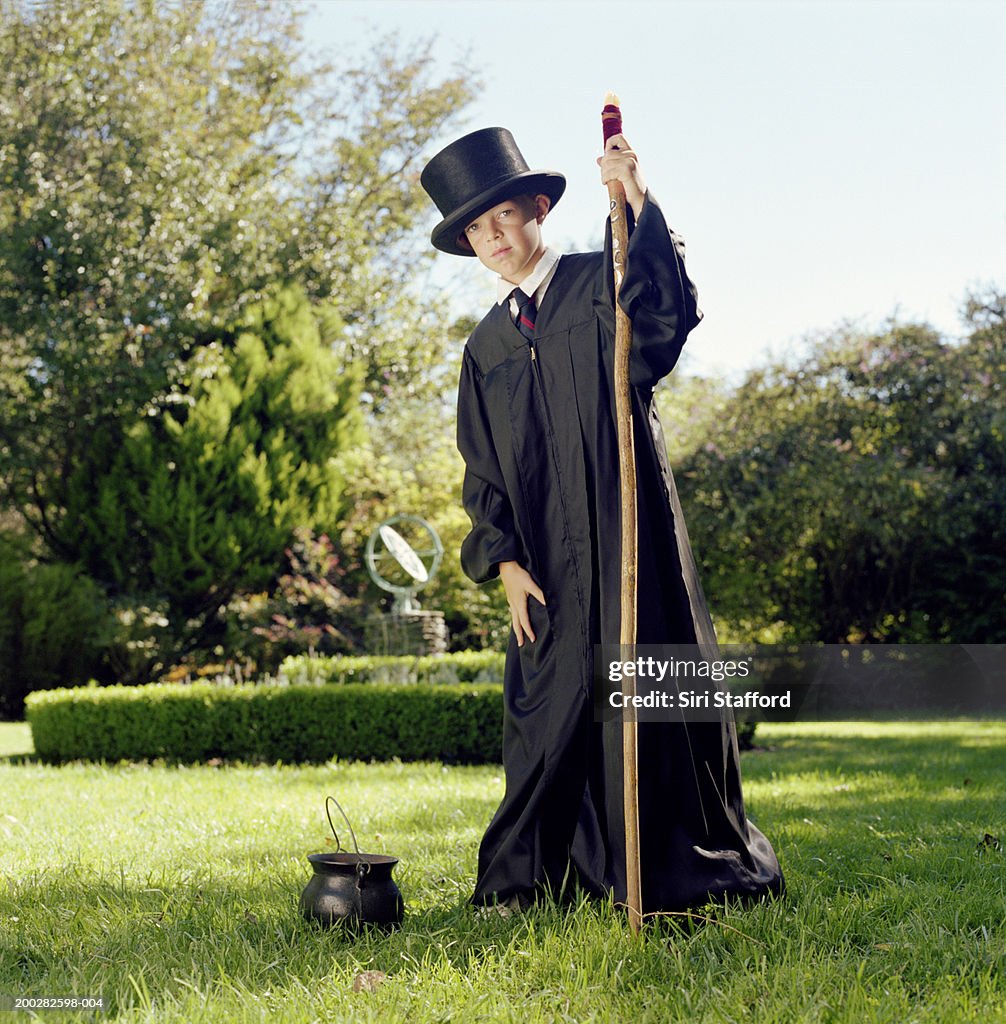 Boy (9-11) wearing costume, holding stick