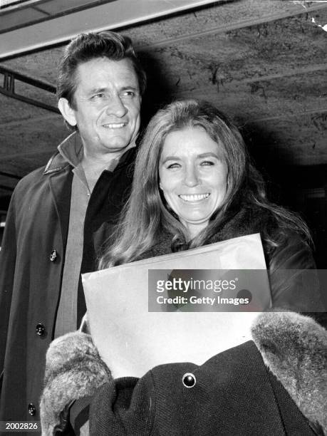 American country singer and songwriter Johnny Cash and his wife June Carter Cash of the Carter Family group arrive May 1, 1968 at London Airport in...