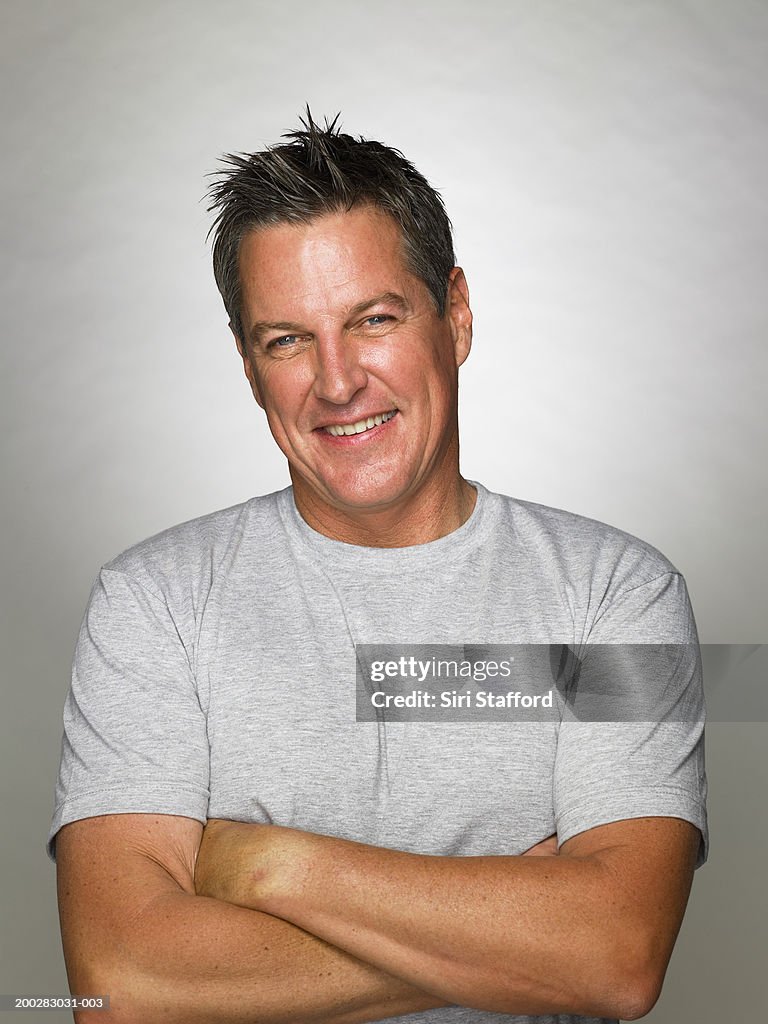 Mature man smiling, arms crossed