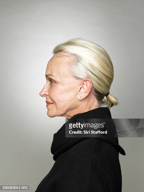senior woman wearing black top, profile - profile stockfoto's en -beelden