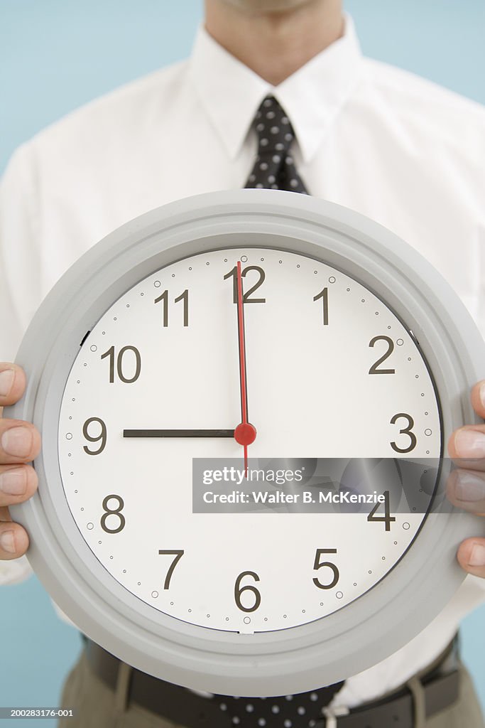 Businessman holding clock