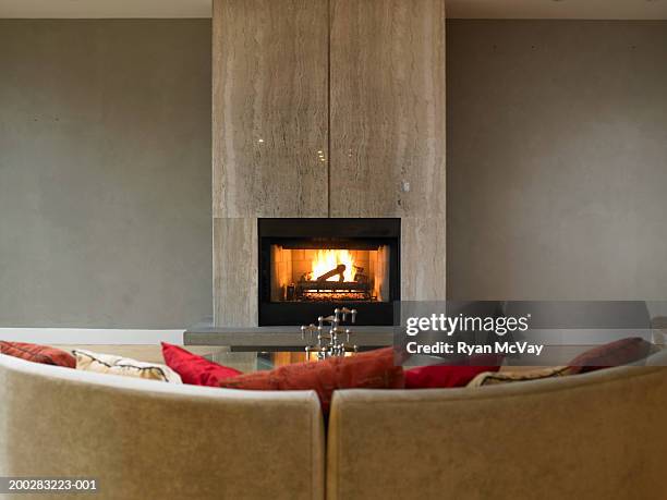 sofa in front of fireplace - kaminfeuer stock-fotos und bilder