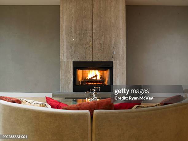 sofa in front of fireplace - chimenea fotografías e imágenes de stock