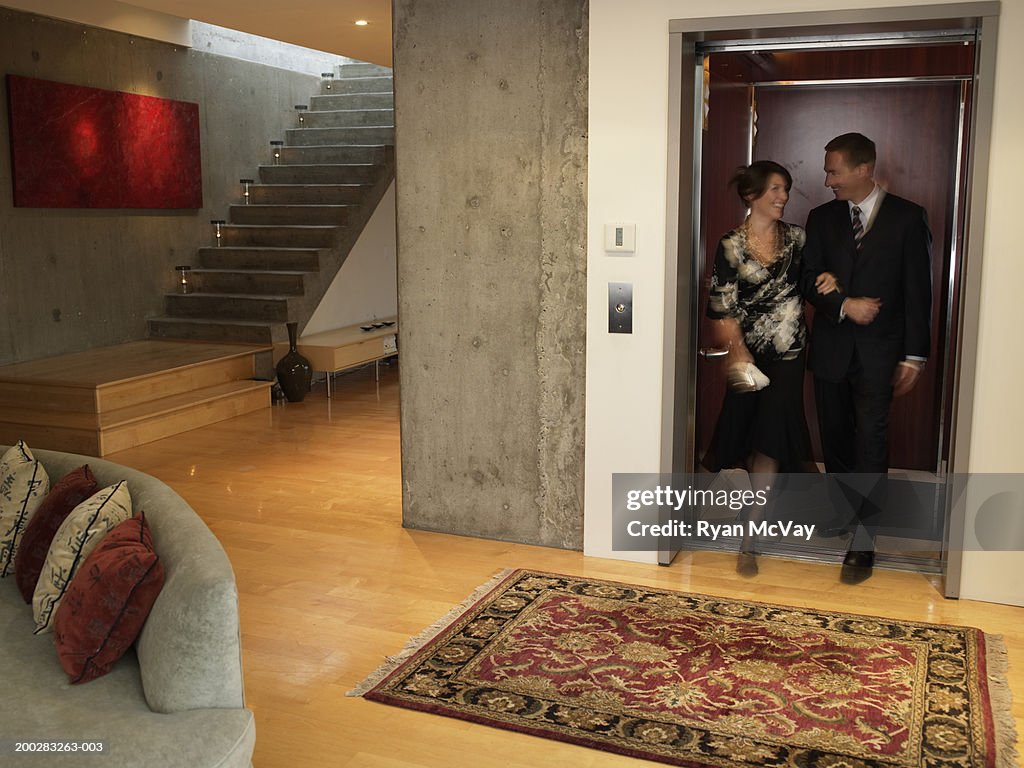 Couple stepping off elevator into living room (blurred motion)