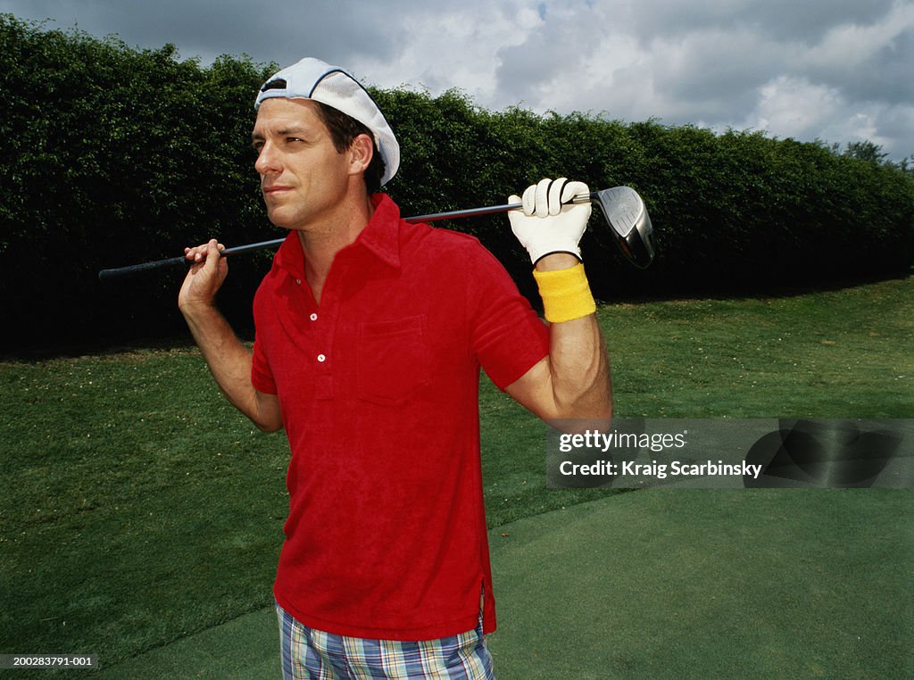 Man holding golf club across shoulders