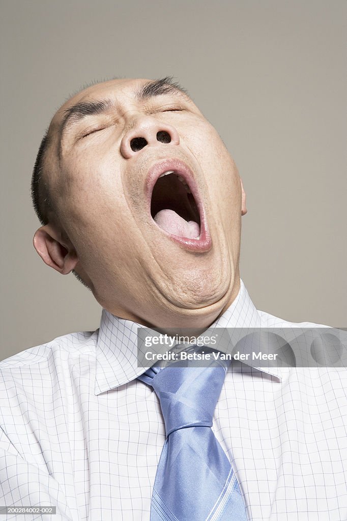 Mature man yawning, eyes closed, close-up