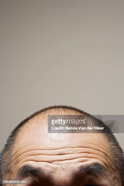 mature man raising eyebrows, high section, close-up - forehead stock-fotos und bilder