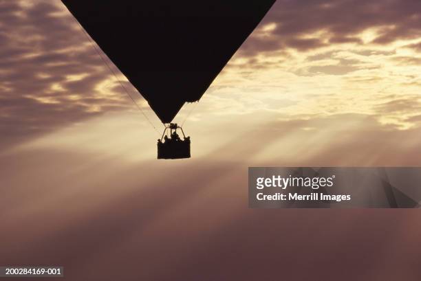 hot air balloon silhouetted against sunbeams and clouds, sunset - emerging from ground stock pictures, royalty-free photos & images