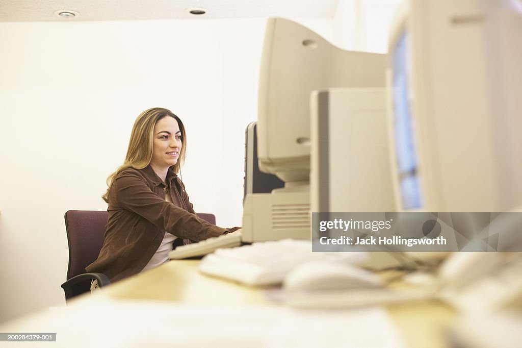 Side profile of a young woman using a computer in an office