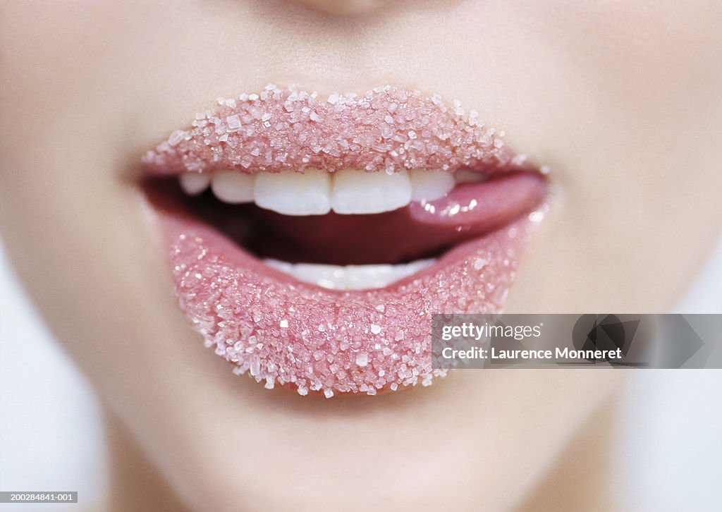 Teenage girl (16-18) lips with sugar, close-up