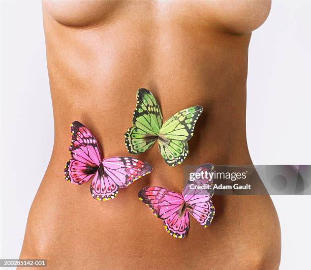 woman with model butterflies over abdomen, mid section - butterflies in the stomach stock-fotos und bilder