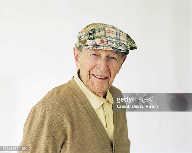 senior man wearing hat, smiling, portrait - cardigan stock-fotos und bilder