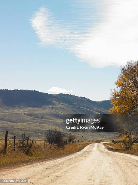 usa, montana, bozeman, dirt road beside hill, autumn - bozeman stock pictures, royalty-free photos & images