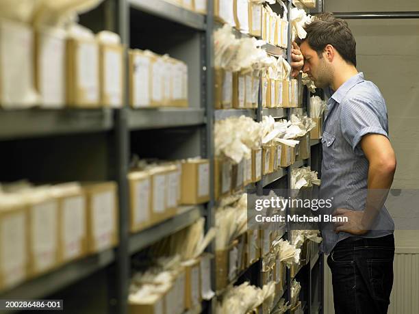 man leaning against rows of boxes in storage room - archive 2008 stockfoto's en -beelden