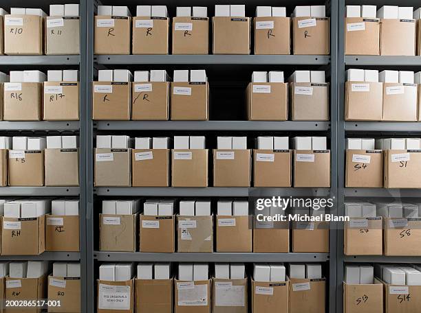 one box missing from rows of boxes on shelves - archief stockfoto's en -beelden