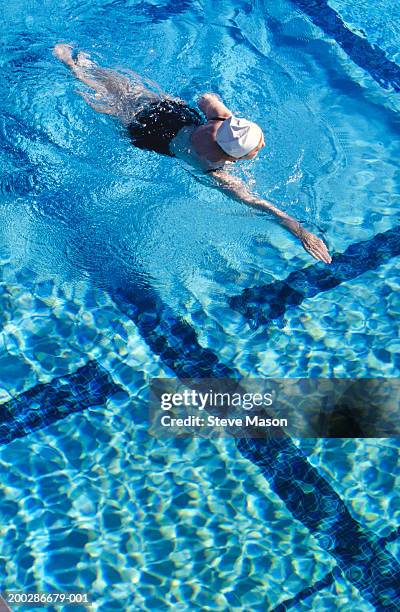 senior woman swimming in pool, elevated view - senior swimming stock pictures, royalty-free photos & images