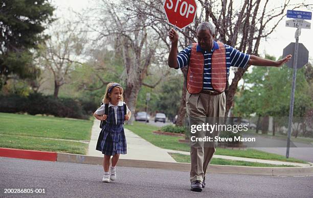 girl (4-5) crossing street with crossing guard - placa de travessia de crianças - fotografias e filmes do acervo