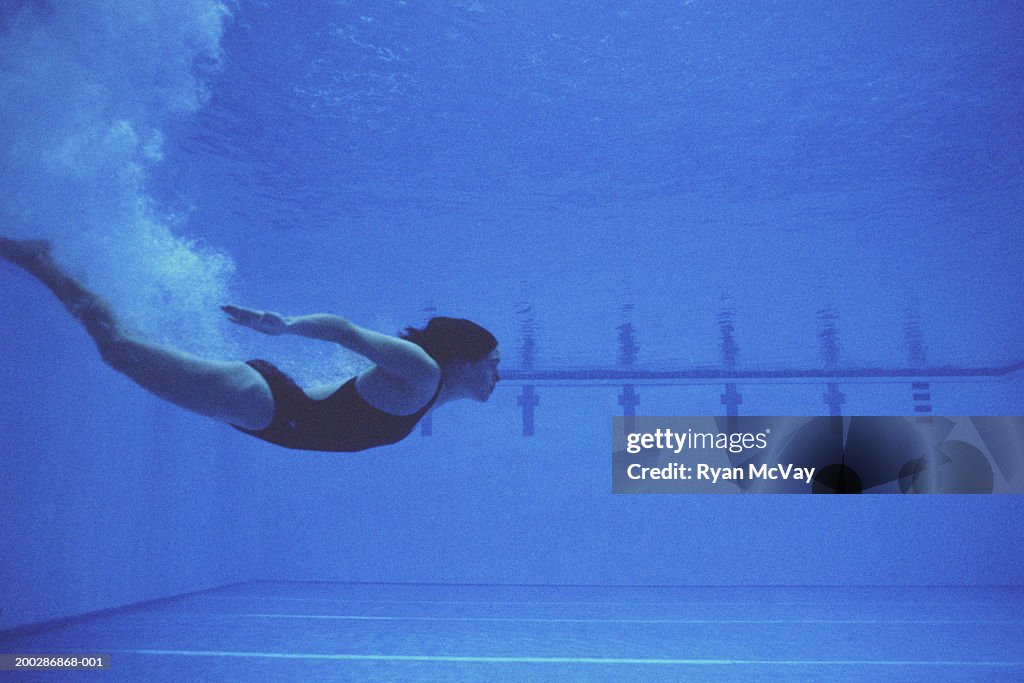 Woman Diving Into Swimming Pool Underwater View Photo - Getty Images