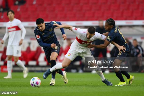 Deniz Undav of VfB Stuttgart is challenged by Nadiem Amiri and Leandro Barreiro of 1.FSV Mainz 05 during the Bundesliga match between VfB Stuttgart...