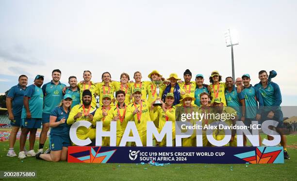 Hugh Weibgen, Captain of Australia, and Harry Dixon lift the ICC U19 Men's Cricket World Cup trophy as players of Australia pose for a team...