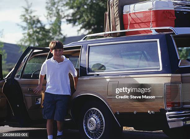 boy (6-7) getting out of station wagon - station wagon stock pictures, royalty-free photos & images