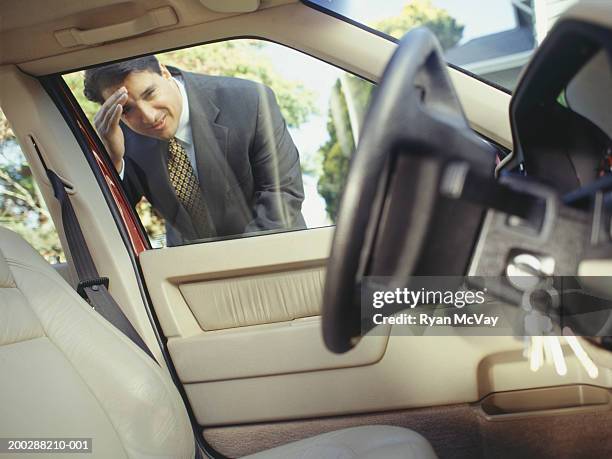 businessman looking through window at keys locked in car - car interior stock pictures, royalty-free photos & images