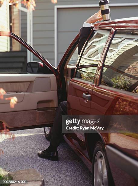 Man Reaching For Coffee Flask On Car Roof, 照片檔