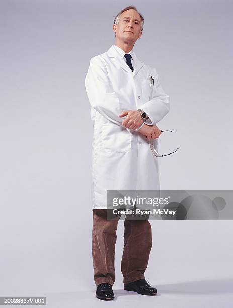male doctor standing indoors, portrait - overcoat stock pictures, royalty-free photos & images